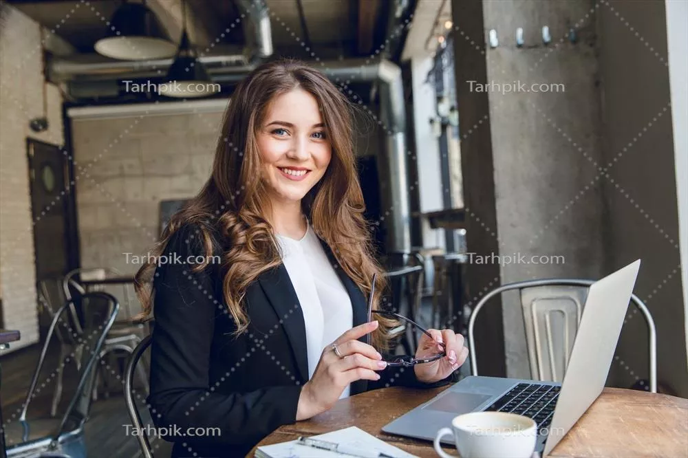 عکس کارمند خندان در حال کار با لپ تاپ