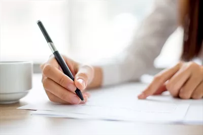 عکس کارمند در حال نوشتن روی کاغذ