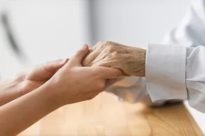 عکس دستان زن سالمند در دست پرستار