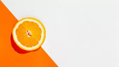 عکس برش پرتقال روی قاب نارنجی با فضای کپی