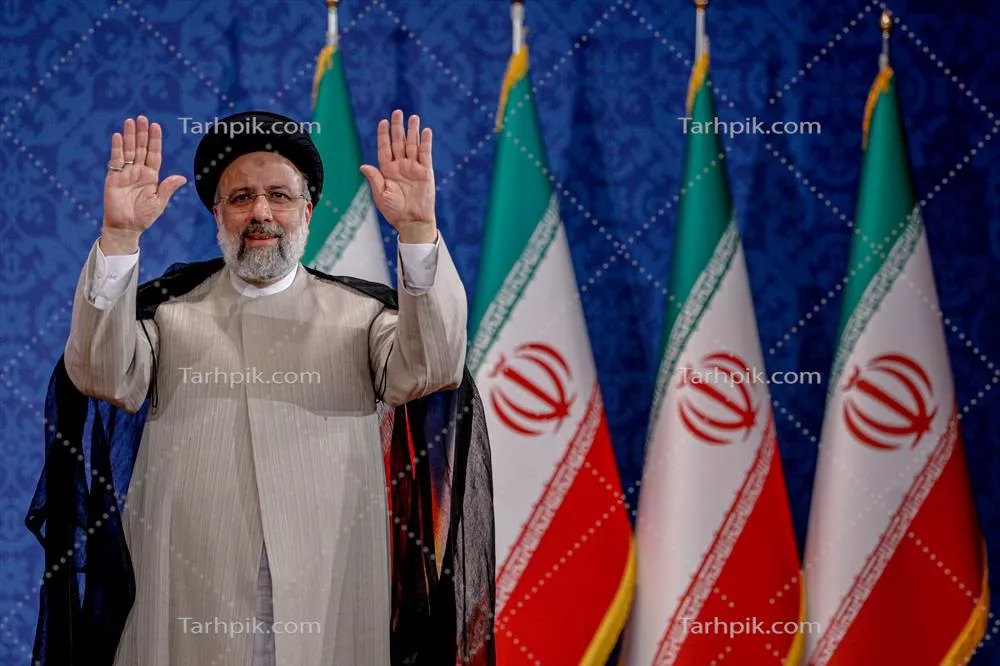 عکس مرحوم شهید سید ابراهیم رئیسی در حال سلام دادن هنگام سخنرانی کنار پرچم ایران