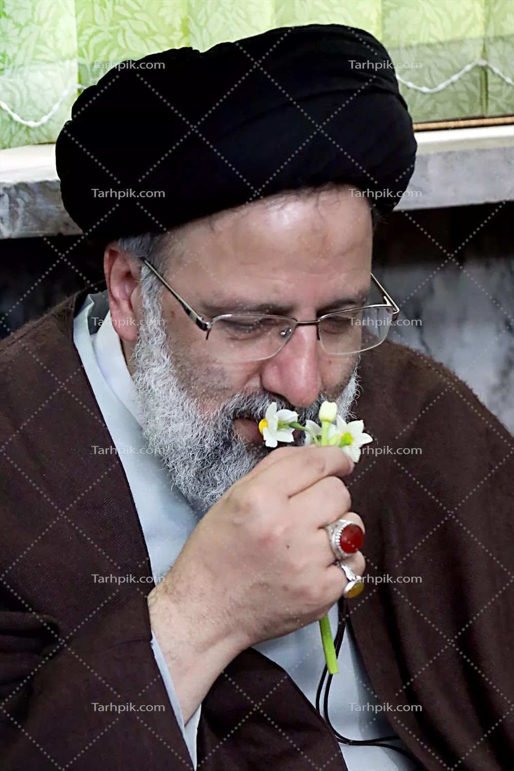 عکس شهید سید ابراهیم رئیسی در حال بو کردن گل نرگس