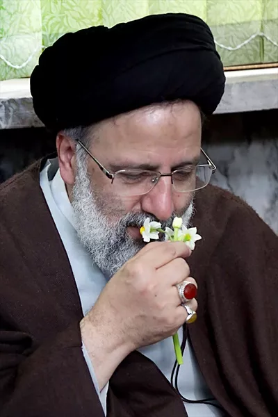عکس شهید سید ابراهیم رئیسی در حال بو کردن گل نرگس