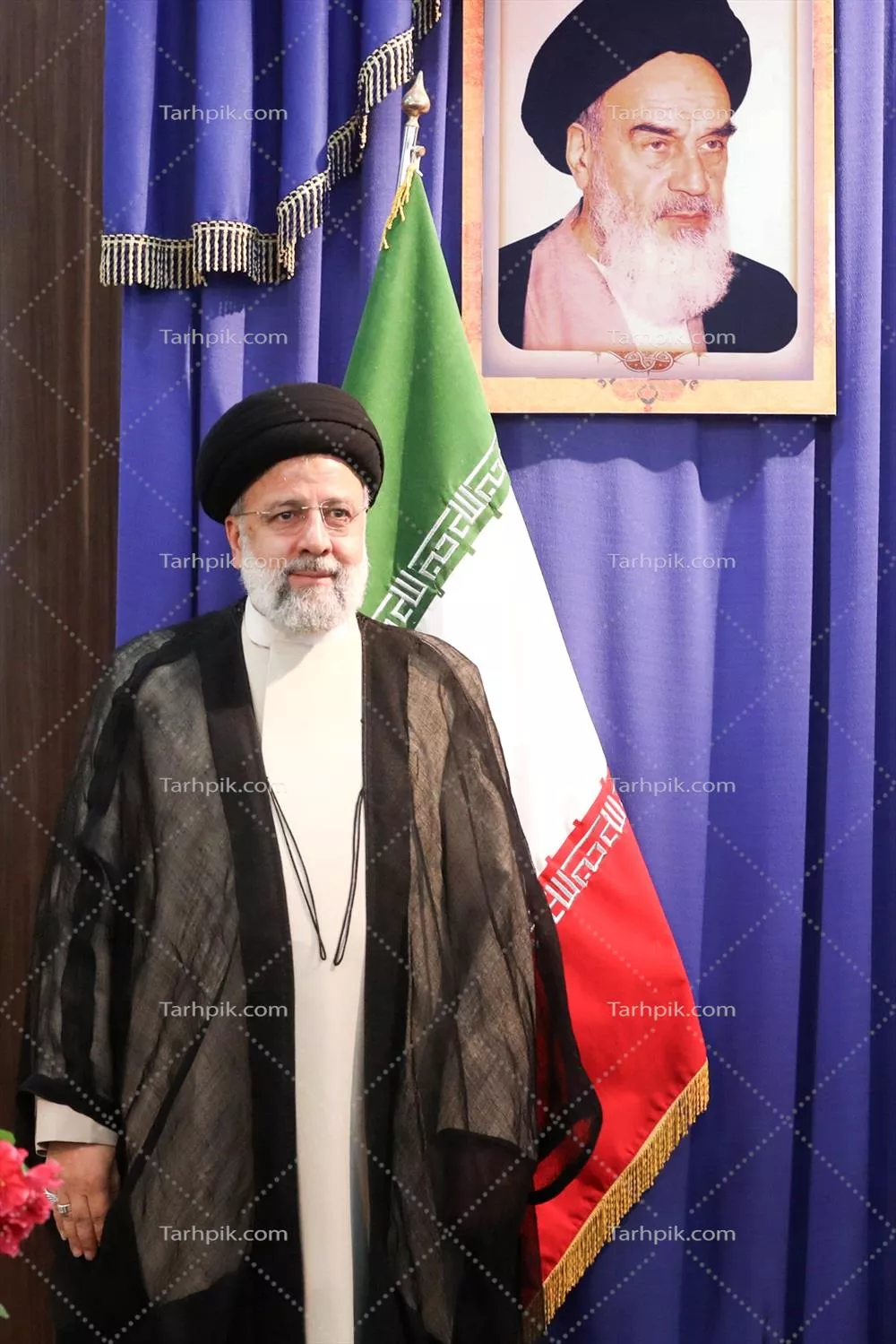 عکس ایستاده شهید سید ابراهیم رئیسی با عکس امام خمینی و پرچم ایران