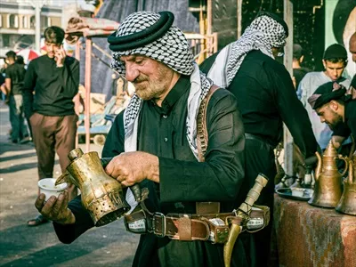 عکس قهوه ریختن موکب دار کربلا برای زائرین پیاده اربعین