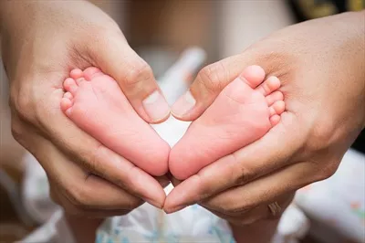 عکس پاهای کودک در دستان پدر