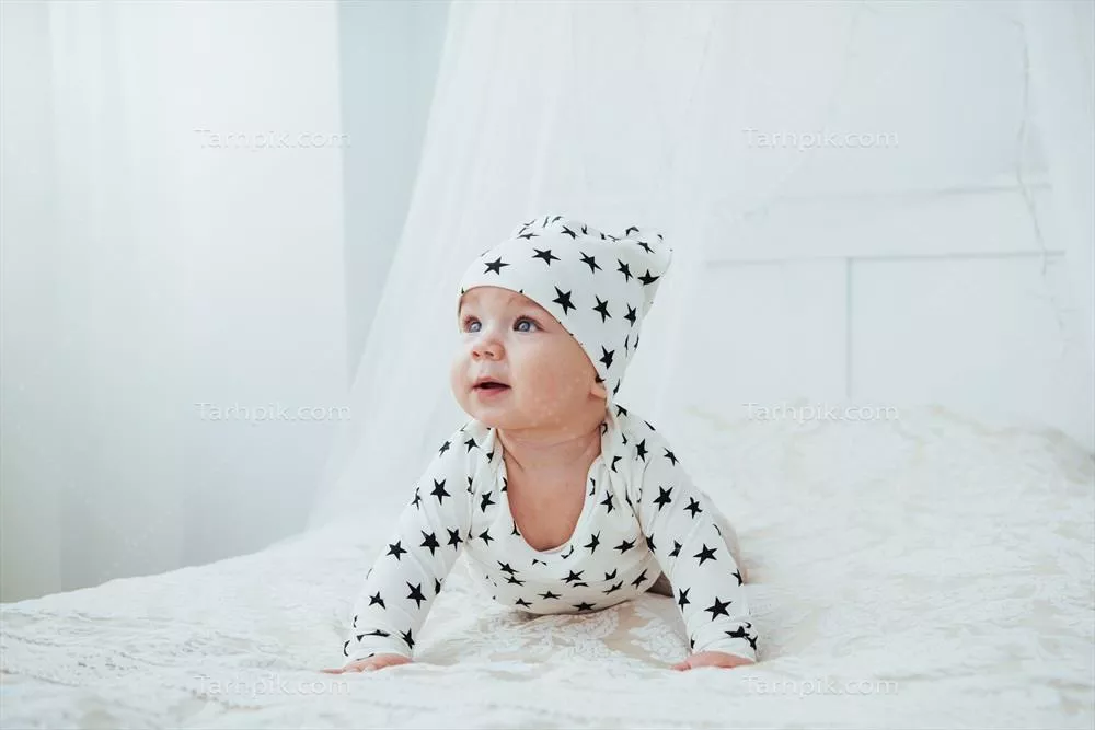 عکس نوزاد تازه به دنیا اومده روی تخت برای عکاسی در آتلیه