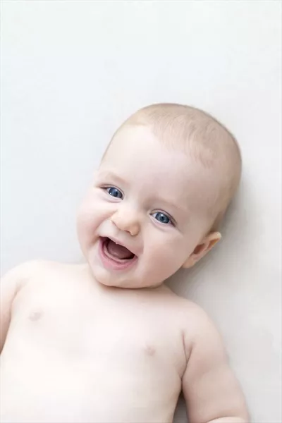 عکس دختر بچه ناز و خندان روی تخت