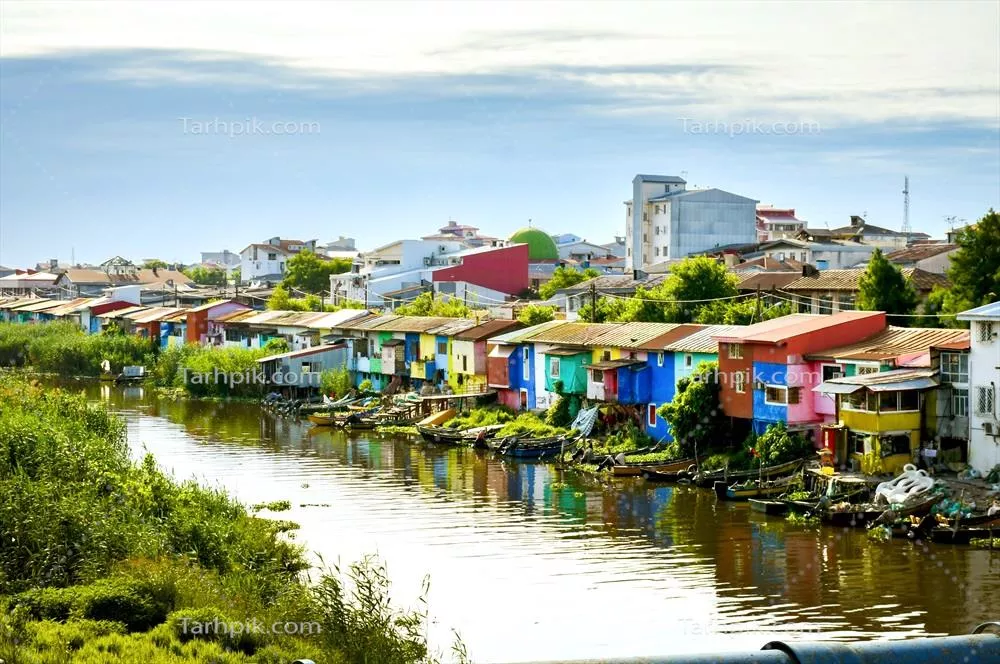 عکس نمایی از خانه های رنگارنگ در کنار رودخانه ای آرام و زیبا