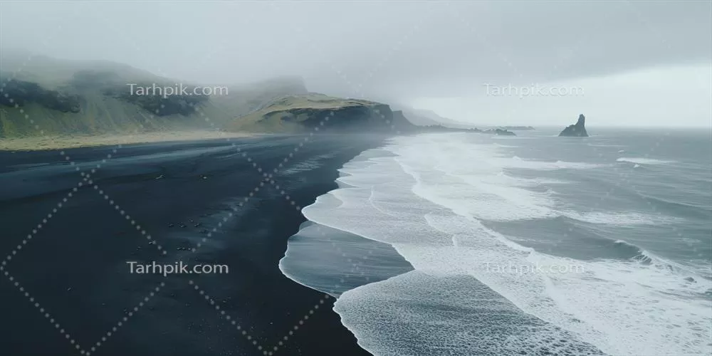 عکس ساحل شنی سیاه و مه آلود با امواج آرام در یک روز ابری