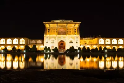 عکس ورود به مسجد جامع اصفهان در شب با باغی زیبا در پیش زمینه