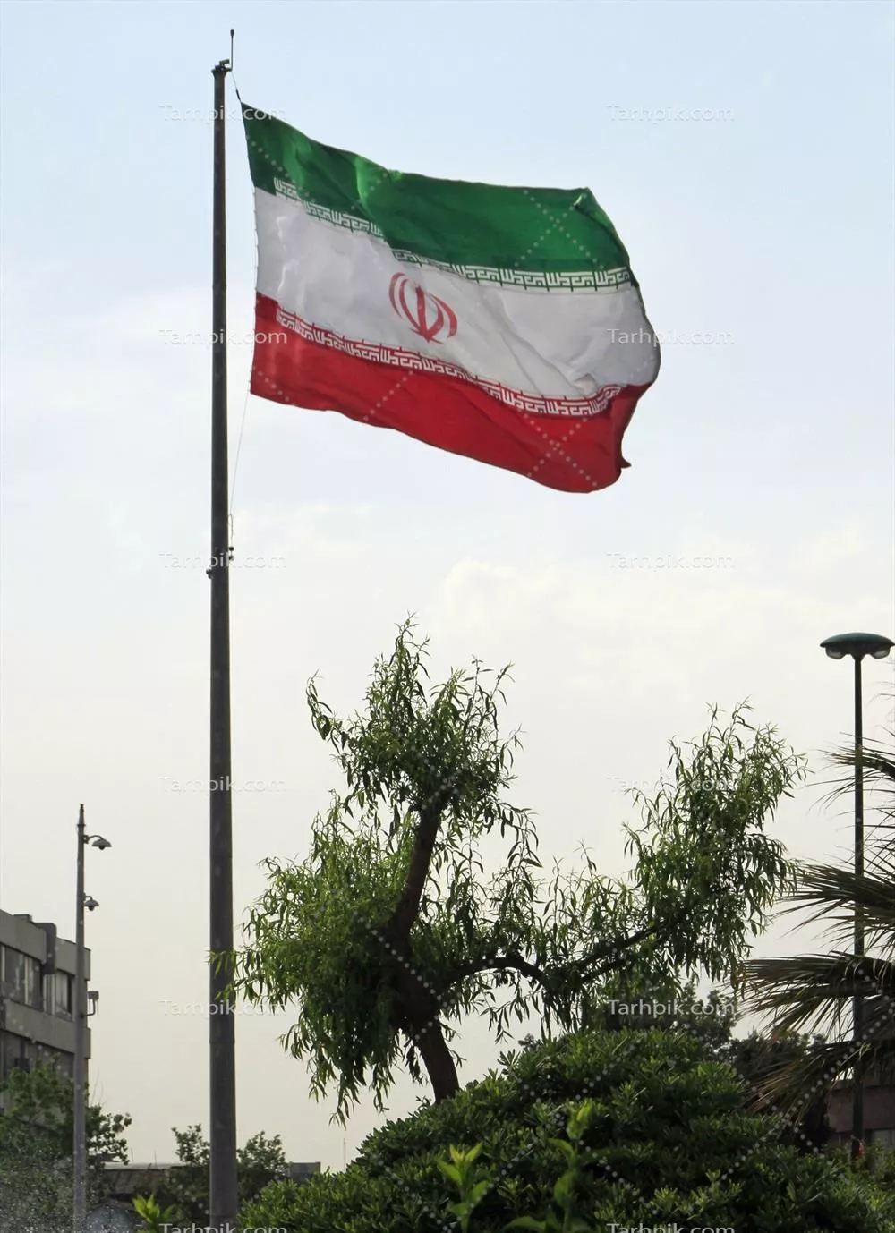 عکس پرچم بزرگ ایران در حال وزیدن در تهران، نمادی از وحدت و افتخار ملی