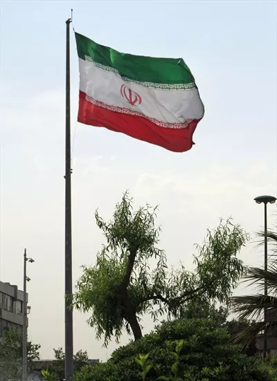 عکس پرچم بزرگ ایران در حال وزیدن در تهران، نمادی از وحدت و افتخار ملی