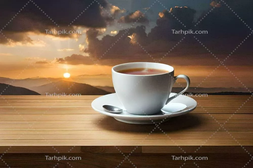 عکس یک فنجان چای روی میز چوبی با نمایی از کوه ها در دل طبیعت