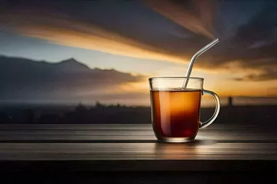 عکس یک فنجان چای داغ بر روی میز چوبی در غروب آفتاب زیبا