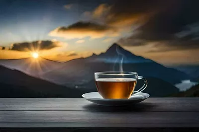 عکس یک فنجان چای بر روی میز چوبی با نمای کوهستانی زیبا