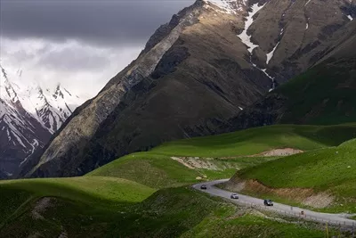 عکس منظره ای زیبا از کوه ها و جاده ای منحنی در گرجستان