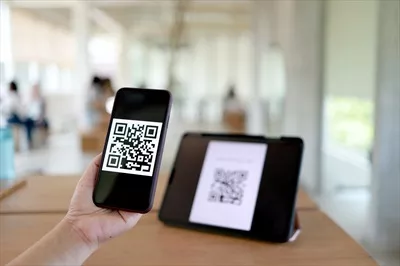عکس زنی که در حال خرید آنلاین با استفاده از کد QR است و تکنولوژی بدون پول را تجربه می کند