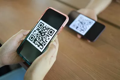 عکس زنی که در حال خرید آنلاین با استفاده از کد QR است و تکنولوژی بدون پول را تجربه می کند