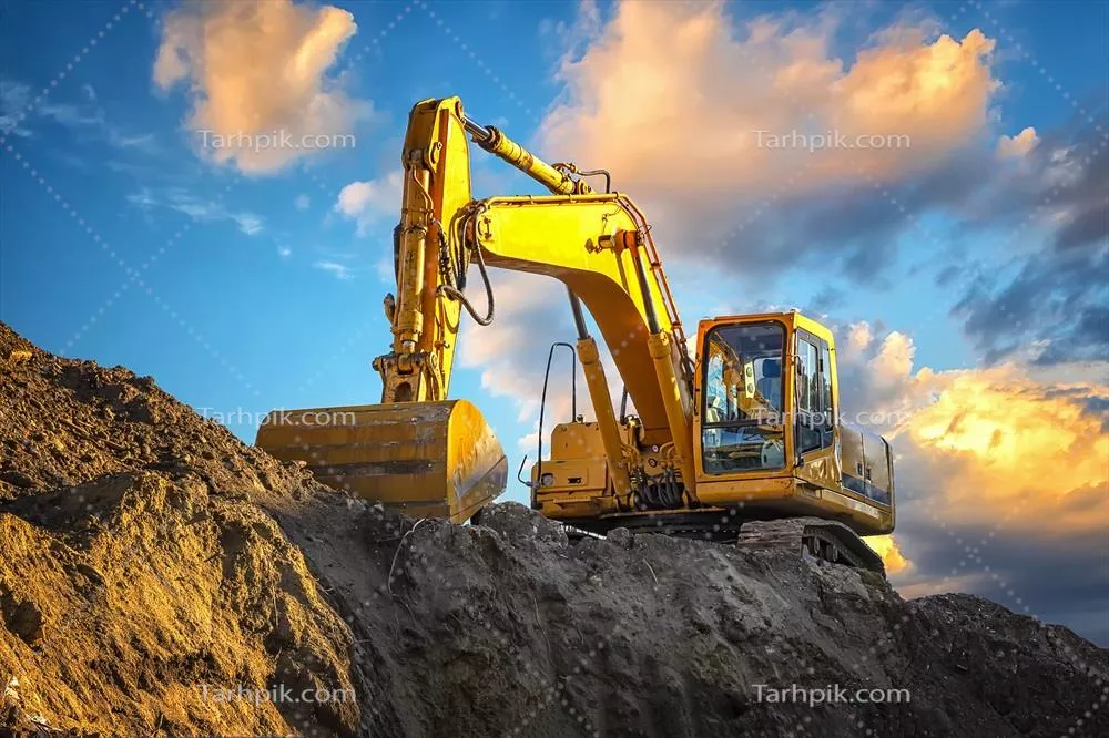 عکس یک بیل مکانیکی زرد در غروب زیبای طبیعت با منظره ای خیره کننده