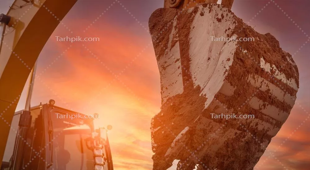 عکس عملیات حفاری با بیل مکانیکی در یک سایت ساختمانی در غروب آفتاب