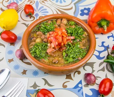 عکس غذای عربی فخاره با گوجه فرنگی، گشنیز و پیاز در ظرف سرو