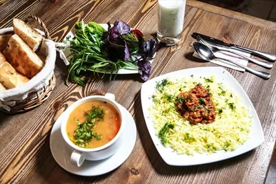 عکس میز چوبی زیبا با ظروف غذا و کاسه سوپ برای مهمانی های دلپذیر