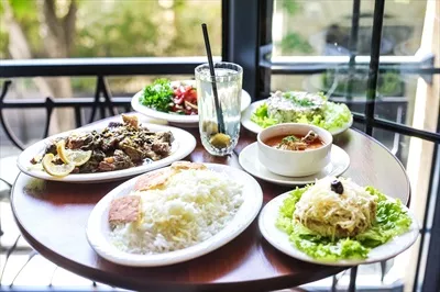 عکس میز غذا با بشقاب های رنگارنگ در کنار پنجره زیبا