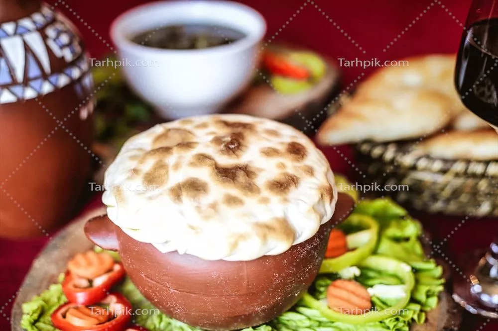 عکس یک وعده غذایی خوشمزه با بشقاب غذا و لیوان شراب روی میز