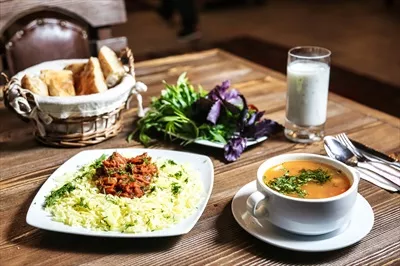 عکس میز چوبی با کاسه سوپ و بشقاب غذا - تصویری از یک وعده دلپذیر