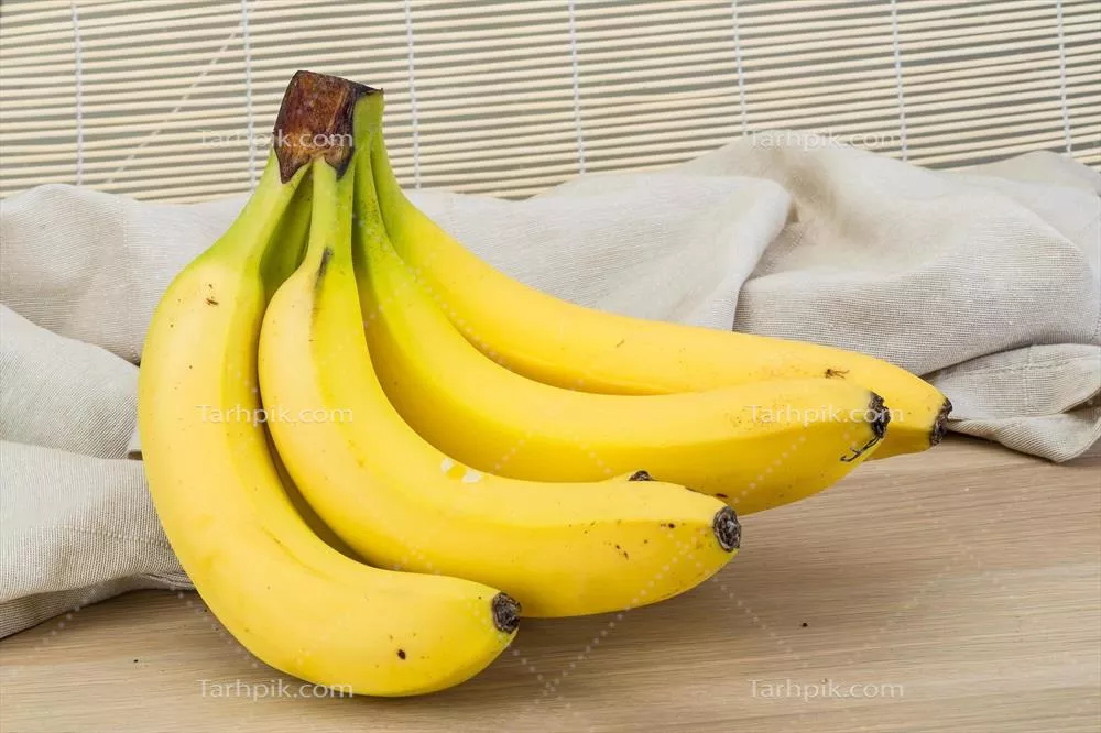 عکس موز تازه بر روی یک تخته چوبی، نمایی زیبا و طبیعی