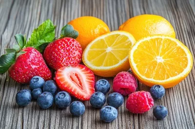 عکس مجموعه ای رنگارنگ و تازه از میوه های تابستانی بر روی میز چوبی