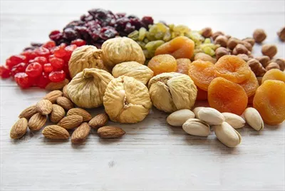 عکس مجموعه ای از میوه های خشک و آجیل های خوشمزه بر روی چوب