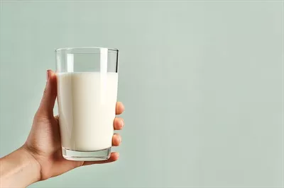 عکس دست گرفتن یک لیوان شیر تازه با فضای خالی برای نوشتن