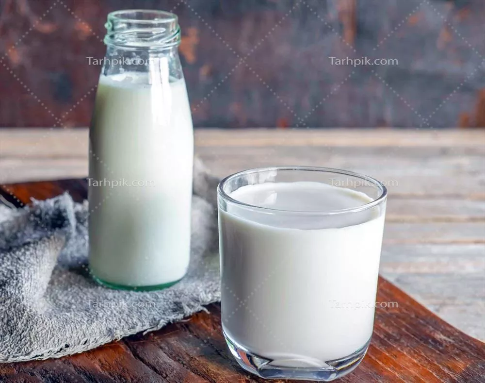 عکس تصویری زیبا از بطری ها و لیوان های شیر بر روی میز چوبی