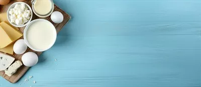 عکس محصولات لبنی شامل شیر، پنیر کاتیج و تخم مرغ بر روی زمینه آبی
