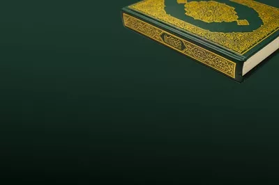 عکس قرآن کریم با خط عربی زیبا و تسبیح در پس زمینه تیره