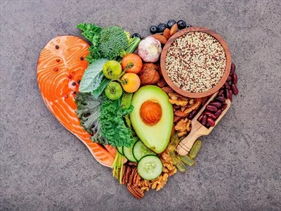 عکس انتخاب مواد غذایی سالم به شکل قلب بر روی پس زمینه سنگی تیره