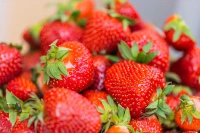 عکس تجربه طعم تازه و خوشمزه توت فرنگی های رسیده در کاسه ای سالم و گیاهی