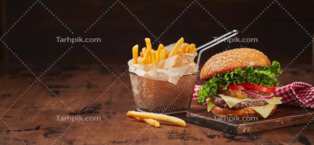 عکس برگر خانگی با گوشت، پنیر و مارمالاد پیاز بر روی تخته چوبی