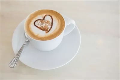عکس یک فنجان قهوه لاته خوشمزه با کف شیر زیبا و دلپذیر