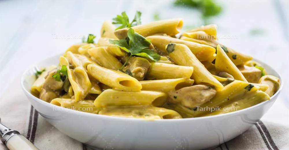 عکس پاستا پنه با تکه های مرغ و قارچ در سس پنیر پارمزان و تزئینات گیاهی