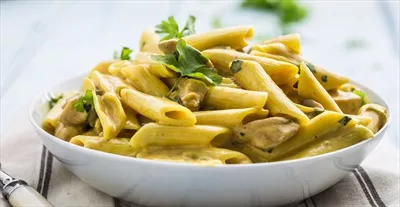 عکس پاستا پنه با تکه های مرغ و قارچ در سس پنیر پارمزان و تزئینات گیاهی