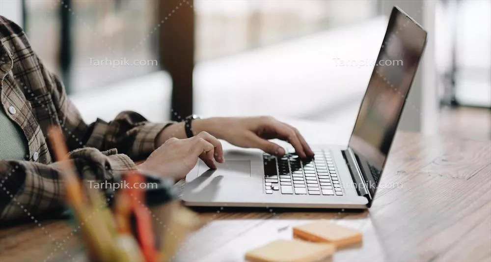 عکس زنی که با لپ تاپ و برنامه ریز خود در حال کار است