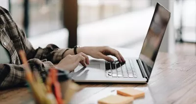 عکس زنی که با لپ تاپ و برنامه ریز خود در حال کار است