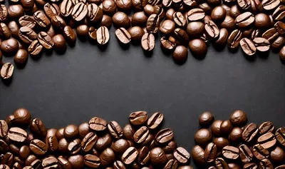 عکس دانه های قهوه تازه برشته شده به عنوان پس زمینه ای جذاب برای ترکیب های قهوه