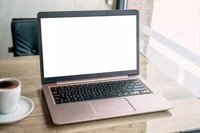 عکس مدل لپ تاپ روی میز کافه با صفحه نمایش خالی برای ارائه وب سایت