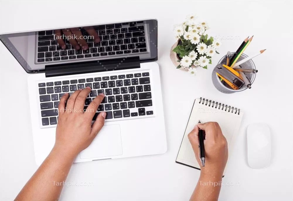 عکس تصویری از یک کارمند مشغول به کار در دفتر با لپ تاپ و اسناد