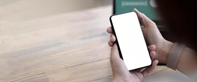 عکس زنی که در حال استفاده از تلفن همراه در دفتر کار خانگی است