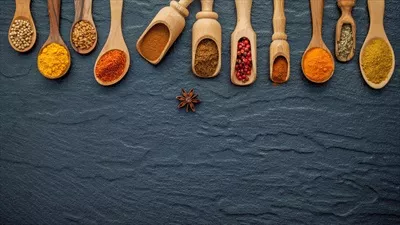 عکس مجموعه ای از ادویه ها و گیاهان معطر در قاشق های چوبی با فضای خالی برای نوشتن